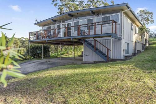 a house with a large deck on the side of it at SeaTreat in Mollymook