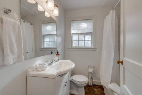 a white bathroom with a sink and a toilet at Nashville's Primrose Cottage In Hip Belmont Area in Nashville