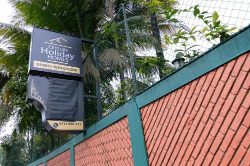 a sign hanging on a fence next to a building at Ceylon Holiday Homes in Kandy