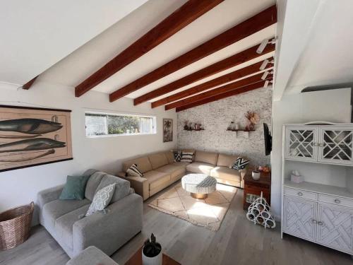 a living room with a couch and a table at Souira Beach House in Manyana