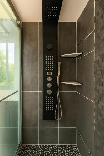 a bathroom with a walk in shower with a phone at Charmant appartement avec jardin, barbecue et Netflix in Méry-sur-Oise
