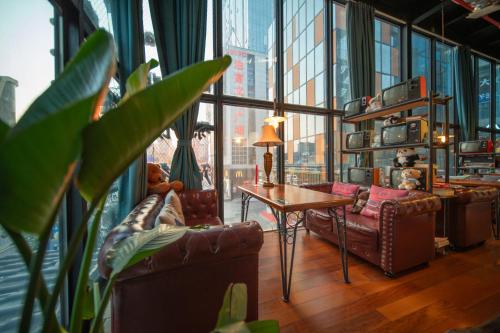 a living room with leather furniture and a large window at Zhangjiajie Wangyi Inn in Zhangjiajie