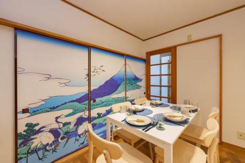 a dining room with a table and a painting on the wall at Oc4 お花茶屋駅から4分の戸建て in Tokyo