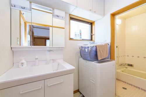 a bathroom with a sink and a washing machine at Oc4 お花茶屋駅から4分の戸建て in Tokyo
