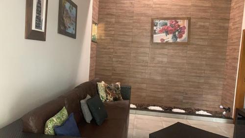 a living room with a brown couch in a room at a Casa Paradisiaca lll Luxo Com Sinuca e Lavanderia com Roupa de Cama e Toalhas in Caldas Novas