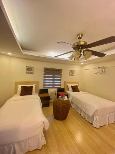 a bedroom with two beds and a ceiling fan at Balai Carmela in Tuguegarao City