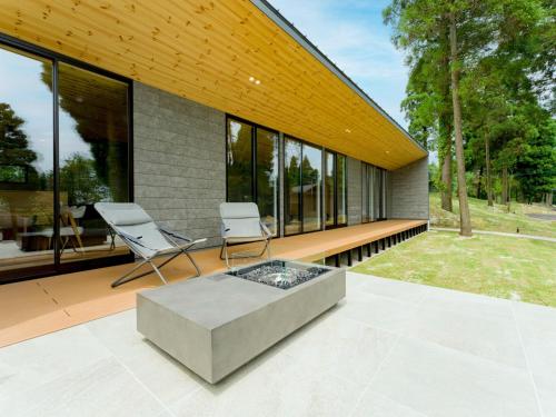 a house with two chairs and a table on a patio at Rakuten STAY VILLA Aso Kurokawa -101 1LDK Capacity of 6 persons in Minamioguni