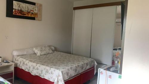 a small bedroom with a bed and a mirror at a Casa Paradisiaca lll Luxo Com Sinuca e Lavanderia com Roupa de Cama e Toalhas in Caldas Novas