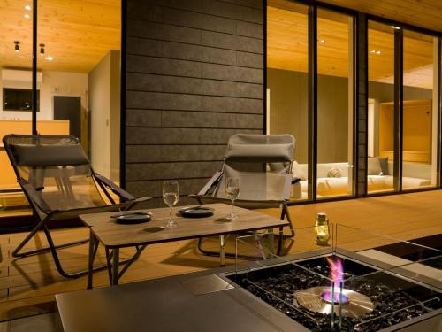 a living room with two chairs and a table with wine glasses at Rakuten STAY VILLA Aso Kurokawa -102 1LDK Capacity of 6 persons in Minamioguni