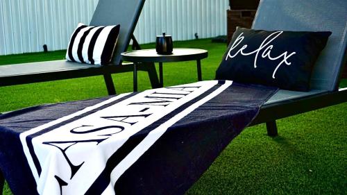a black and white blanket on a bench with a table at CasaMia Only 10 min to Wynwood with New Pool, Bikes, Parking and Privacy in Miami