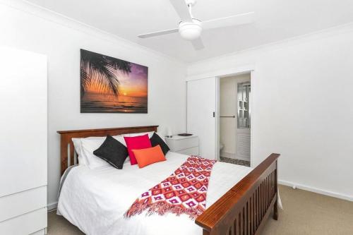 a white bedroom with a bed with at Vue Sur La Mer in Mollymook