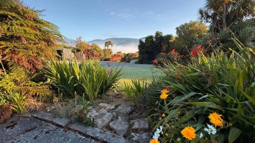 a garden with some flowers and a lawn at Mohua Park - Catlins Eco Accommodation in Owaka