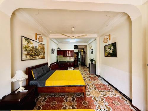 1 dormitorio con 1 cama con manta amarilla en Old Quarter Autumn Hostel Hàng Đào, en Hanói
