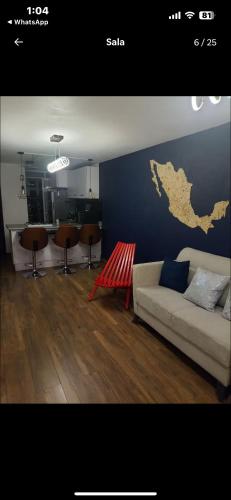 a living room with a couch and a blue wall at Excelente departamento in Mexico City