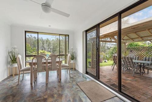 Un comedor con mesa y sillas en Reflections, en Conjola