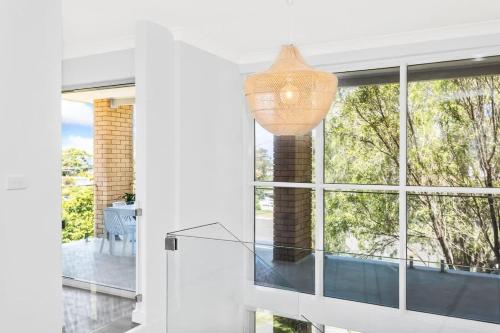 a glass table in front of a large window at Mollymook Delight - with easy ocean & golf access in Mollymook