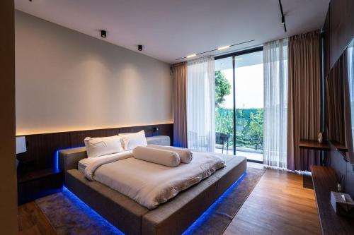 Un dormitorio con una cama grande y una ventana grande. en Villa Blue Sapphire, en Kerobokan