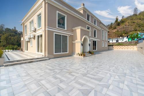 a large house with a stone patio in front of it at SaffronStays Sukh Saklana Haveli Royalty in Dehradun