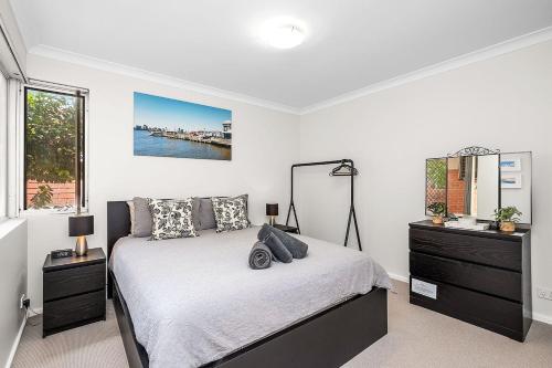 a bedroom with a bed with a dresser and a mirror at 6 Light Bright Home in South Perth in Perth