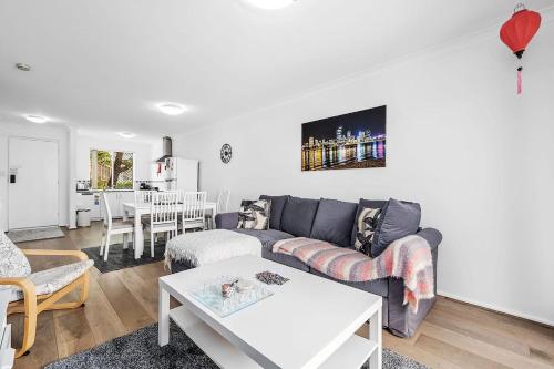 a living room with a couch and a table at 6 Light Bright Home in South Perth in Perth