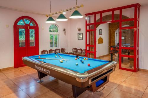 a pool table in a living room with red doors at Krishna Beach Resort in Kannur