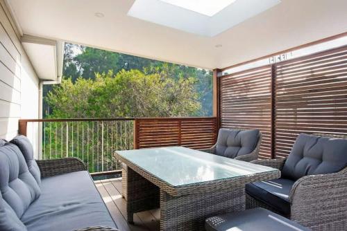 a patio with a table and chairs on a balcony at Yaringa at Bawley in Bawley Point