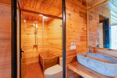 a wooden bathroom with a tub and a toilet at Eco Farmer House - Sapa Retreat in Sa Pa