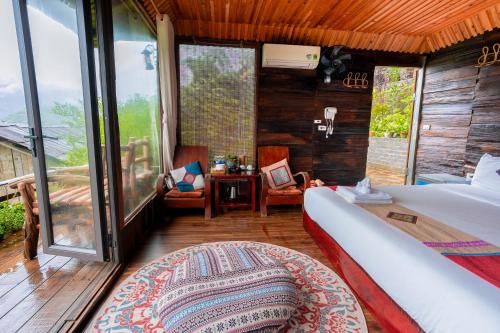 a bedroom with a bed and a large window at Eco Farmer House - Sapa Retreat in Sa Pa