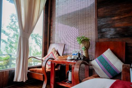 a room with a table and chairs and a window at Eco Farmer House - Sapa Retreat in Sa Pa