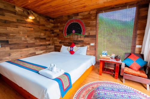 a bedroom with a bed in a room with wooden walls at Eco Farmer House - Sapa Retreat in Sa Pa