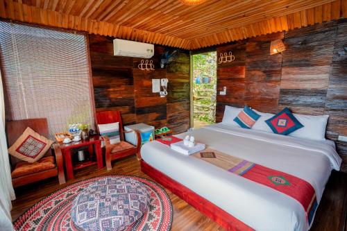 a bedroom with a bed in a room with wooden walls at Eco Farmer House - Sapa Retreat in Sa Pa