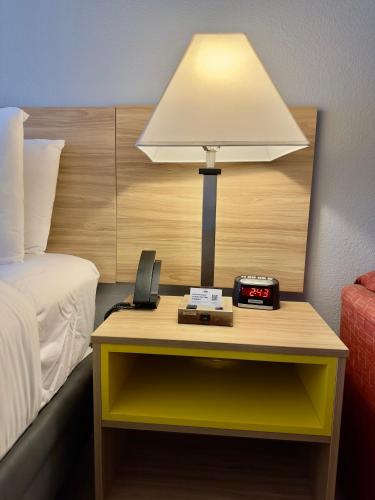 a lamp on a table next to a bed at Days Inn & Suites by Wyndham Lakeland in Lakeland