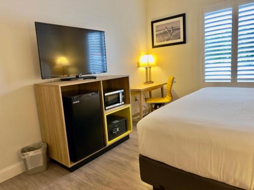 a bedroom with a bed and a flat screen tv at Days Inn & Suites by Wyndham Lakeland in Lakeland