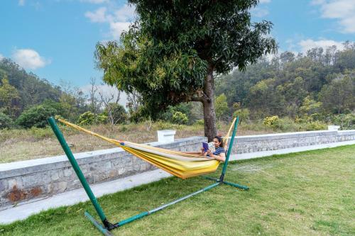 a child sitting in a hammock in a yard at SaffronStays Sukh Saklana Haveli Royalty in Dehradun