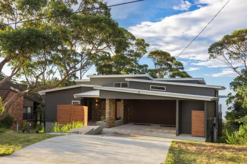 a house in the suburbs with a driveway at Mherringa at Bawley - enjoy panoramic ocean views in Bawley Point