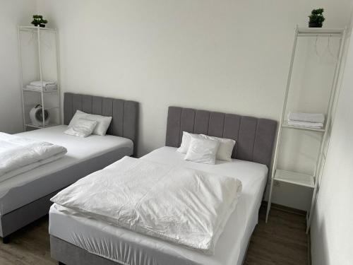 a bedroom with two beds with white sheets at 2-4 People in Peaceful Room Kassel city in Kassel
