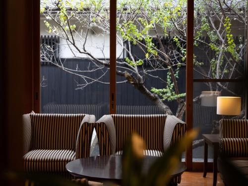 a room with two chairs and a table and a window at Ichiboukan Hanare Kai in Kyotango