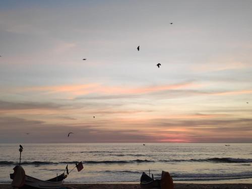 a group of boats on the beach at sunset at Redkar Rooms Gokarna Beach front AC And Non AC Rooms in Gokarn