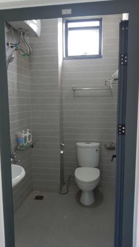 a bathroom with a toilet and a sink and a window at Suoi Da Villa in Ðồn Bãi Cả
