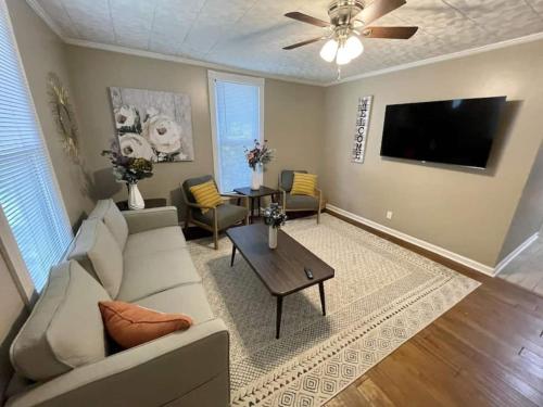 a living room with a couch and a flat screen tv at The Yellow Cottage By Tims Ford Lake in Winchester