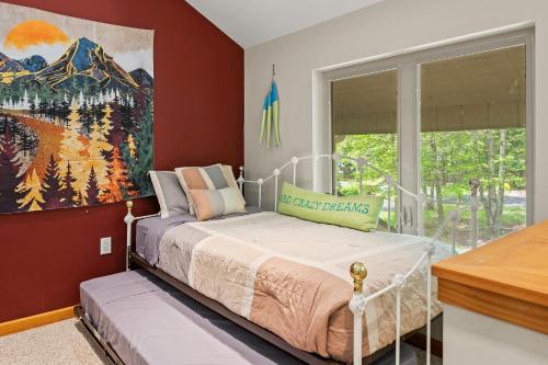 a bedroom with a bed and a painting on the wall at Mountain Hideout by AvantStay Game Room Deck in Albrightsville