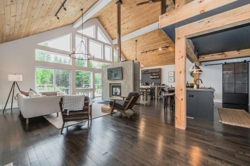 a living room with a couch and a table and a kitchen at Luxury Tobermory Retreat Modern Home and Hot Tub in Tobermory