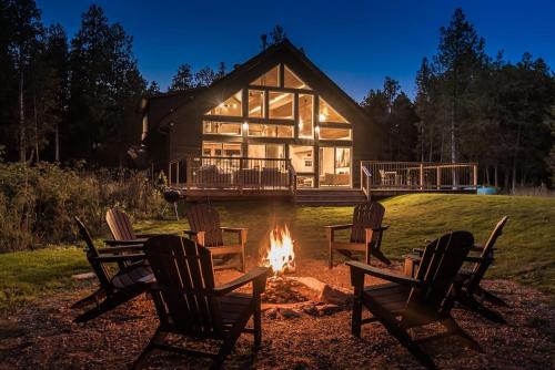 a fire pit in front of a log cabin at Luxury Tobermory Retreat Modern Home and Hot Tub in Tobermory
