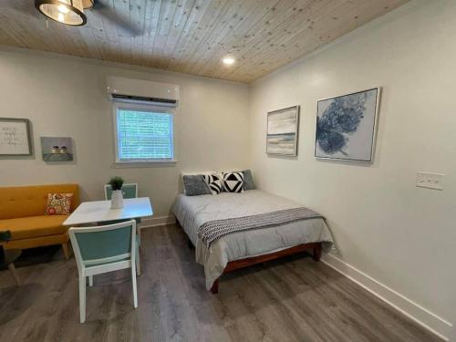 a bedroom with a bed and a table and a chair at Beautifully Renovated Studio 2 Miles From Marina! in Winchester