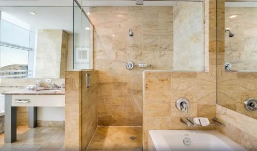 a bathroom with a shower and a tub and a sink at Lux Aka Brickell Condo in Miami
