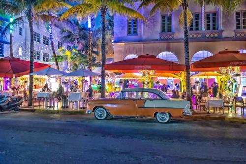 an old car parked on a city street at night at Lux Aka Brickell Condo in Miami