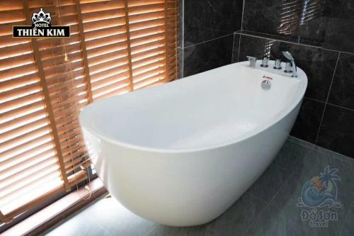 a white bath tub in a bathroom with a window at Anna Belle Đồi Rồng Hotel - Homestay chuỗi HPT Home Hải Phòng in Kon Rung (1)