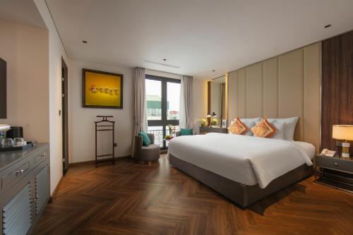 a bedroom with a large white bed and a desk at Léman Old Quarter in Hanoi