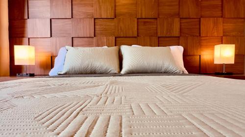 a large white bed with two lamps on tables at Jungle Guardian - Rooftop Pool & Beach Club in Zona Hotelera Tulum in Tulum