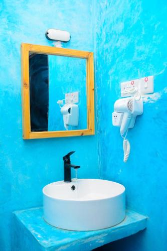 a blue bathroom with a sink and a mirror at Sailors Villa in Jambiani